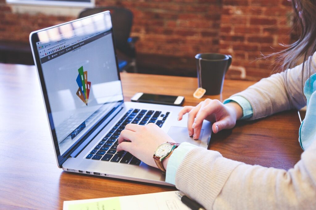 Student proofreading and editing text on a laptop for freelance work.